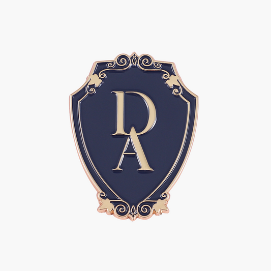 Pin mit Wappen-Logo zur Dunbridge Academy-Reihe in Blau und Gold bei Buchserien.de